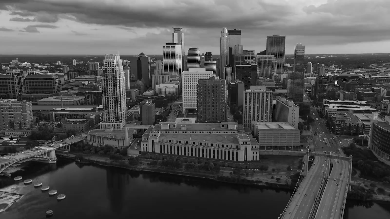 Aerial black-and-white view of the downtown Minneapolis skyline over the Mississippi River